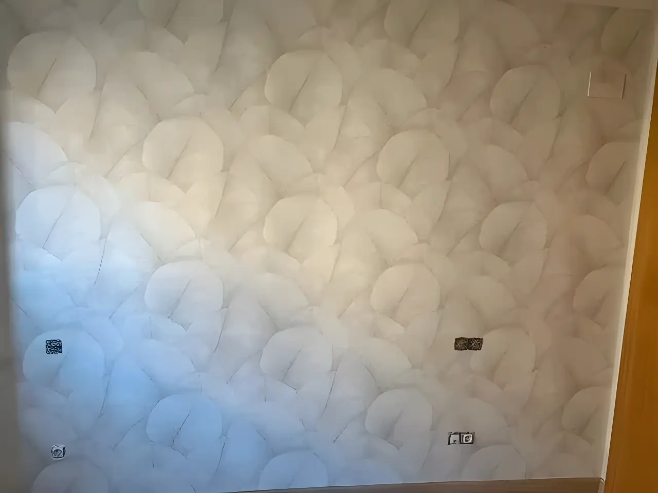 Pintores en Roquetas de Mar aplicando papel pintado de textura clara en salón reformado